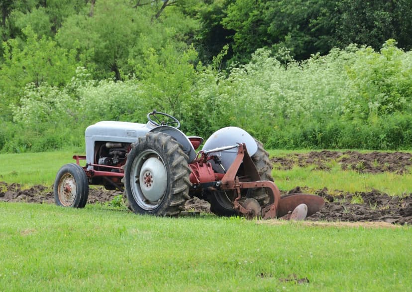 Mann repariert einen Traktor auf dem Feld